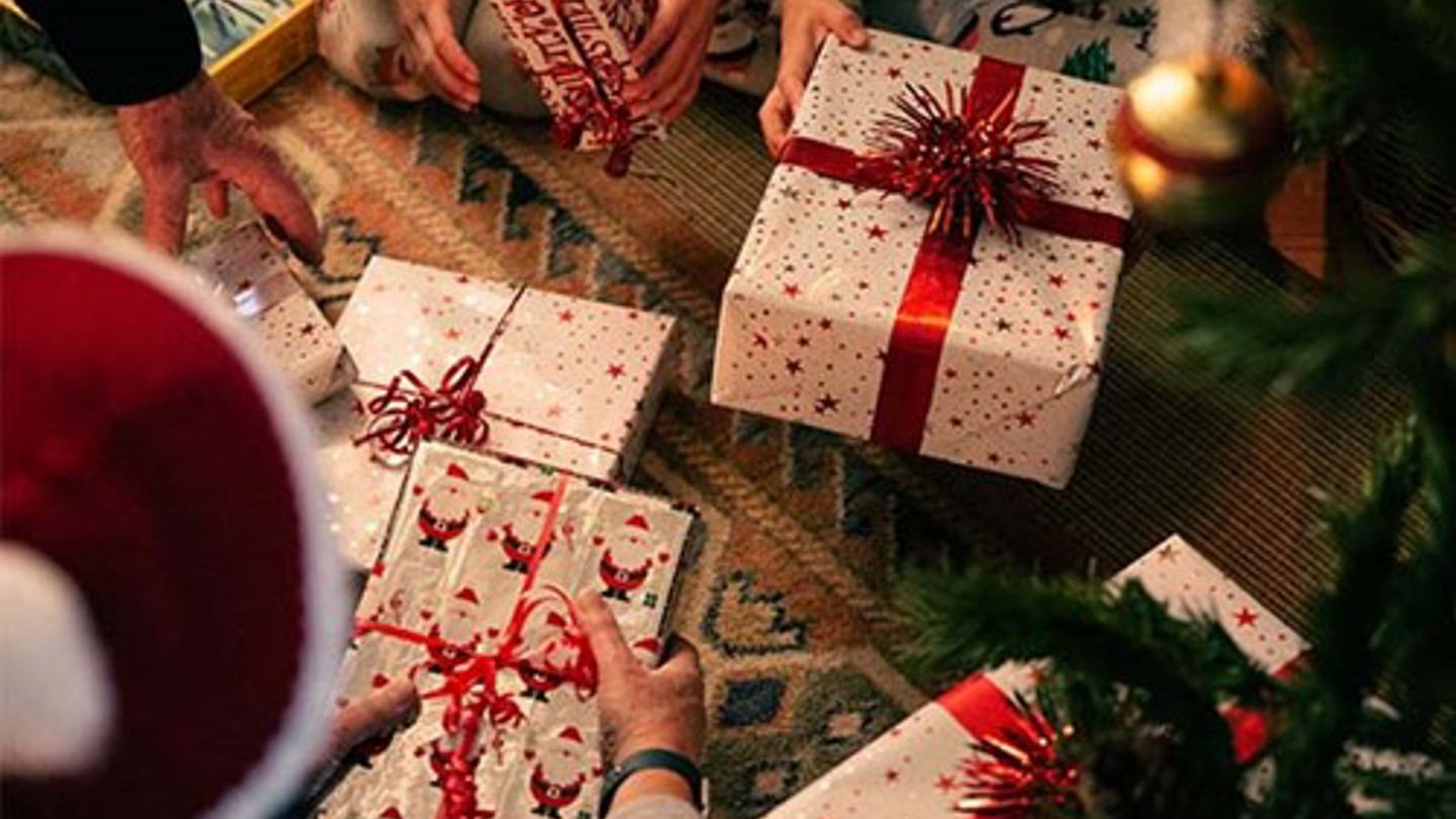 Family sorting through presents under the Christmas tree