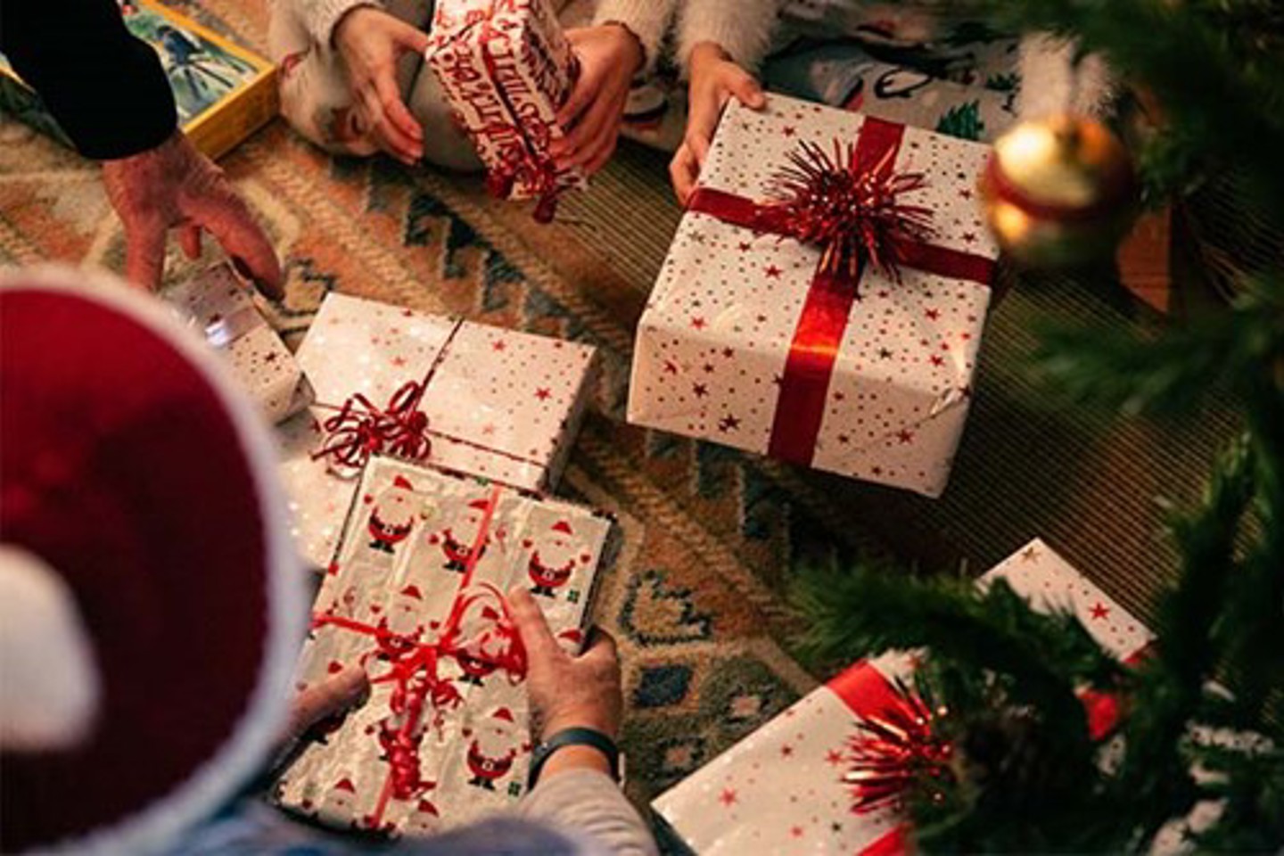 Family sorting through presents under the Christmas tree