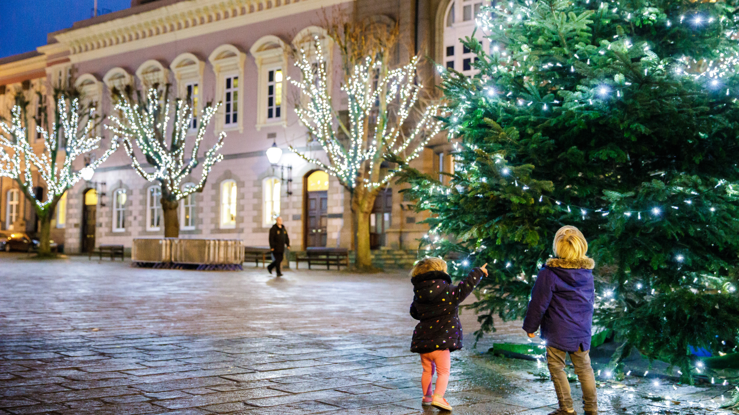 Two small children admiring a Christmas tree in St Helier